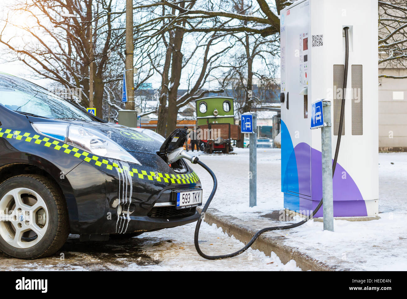 Parnu, Estonia - 10 Gennaio 2016: elettro-taxi marca Nissan alimentata energia elettrica da eco-friendly high-tech stazione di ricarica batterie. Tecnologia moderna Foto Stock