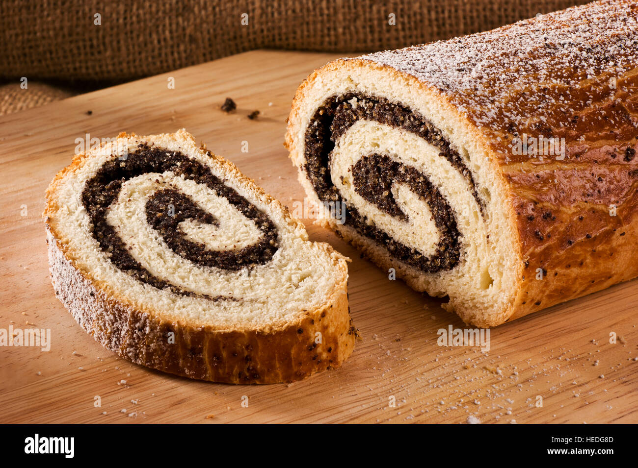 Tradizionale ungherese torta folk xmas poppy rotoli su un tagliere di legno Foto Stock