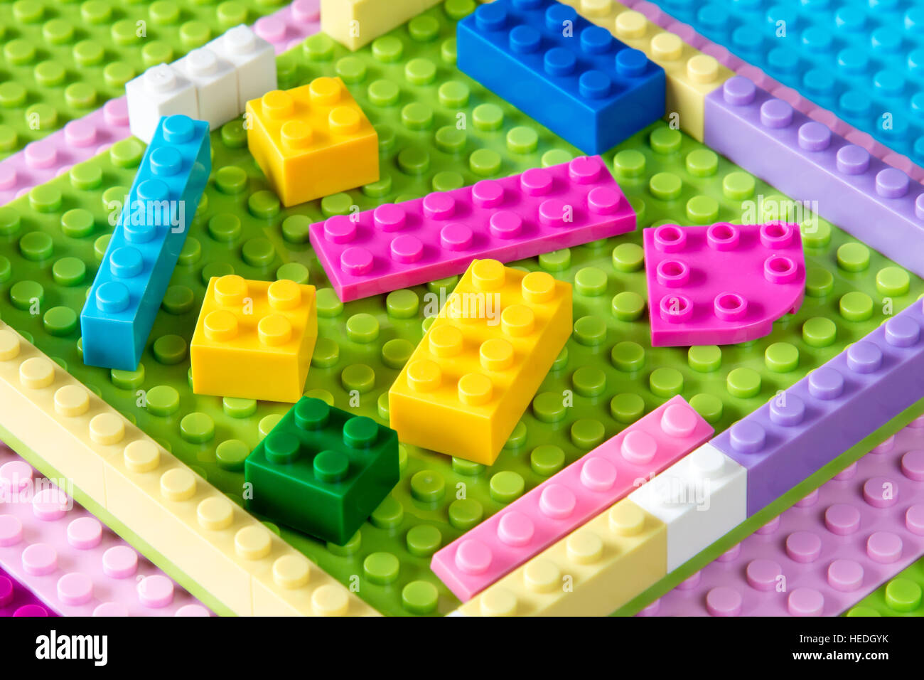Piastra di base con la plastica colorata blocchi di costruzione. Giocattoli sfondo. Foto Stock