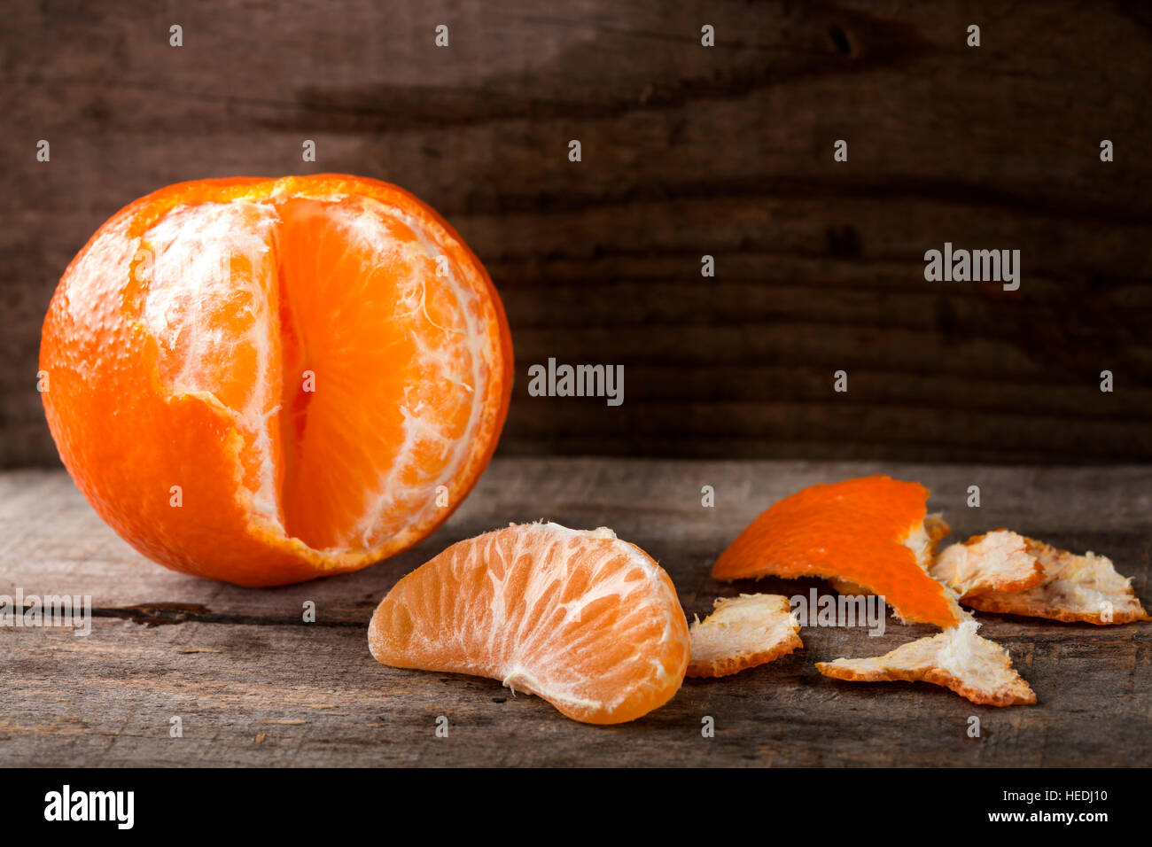 Freschi sbucciati mandarino e uno strato su un tavolo di legno Foto Stock