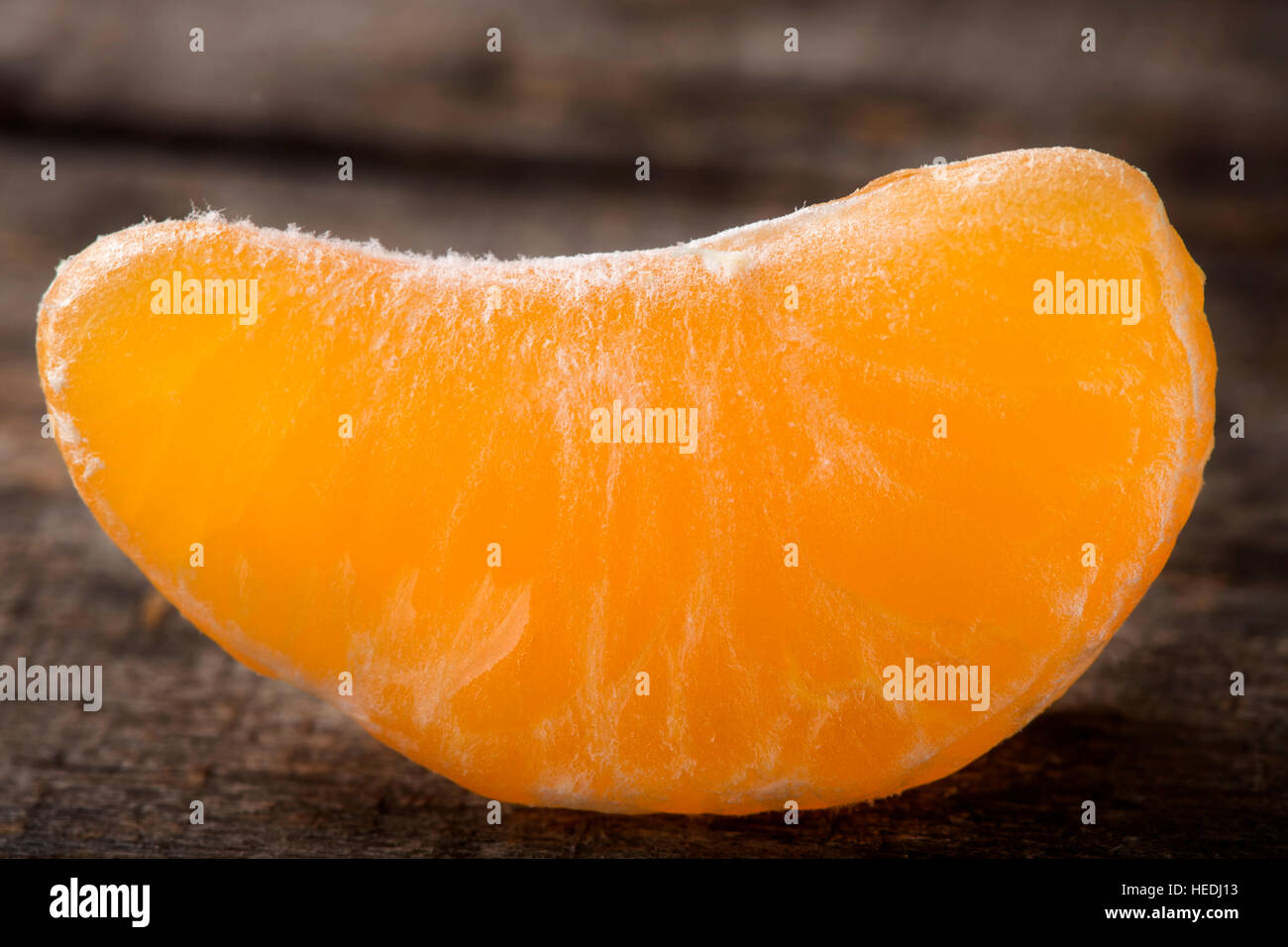 In prossimità di uno pelato tangerine fette sopra lo sfondo di legno Foto Stock