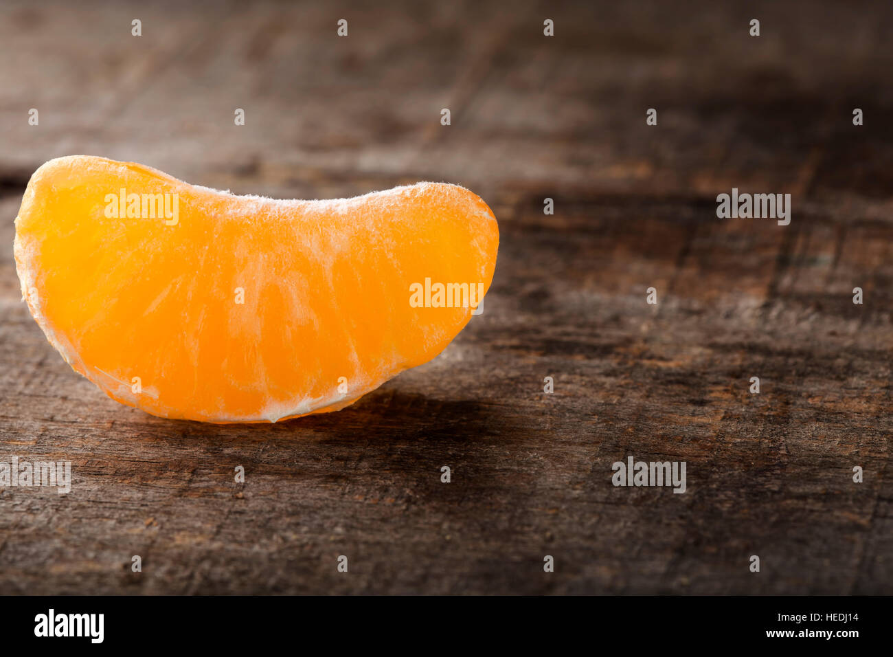 In prossimità di uno pelato tangerine fette sopra lo sfondo di legno con spazio di copia Foto Stock