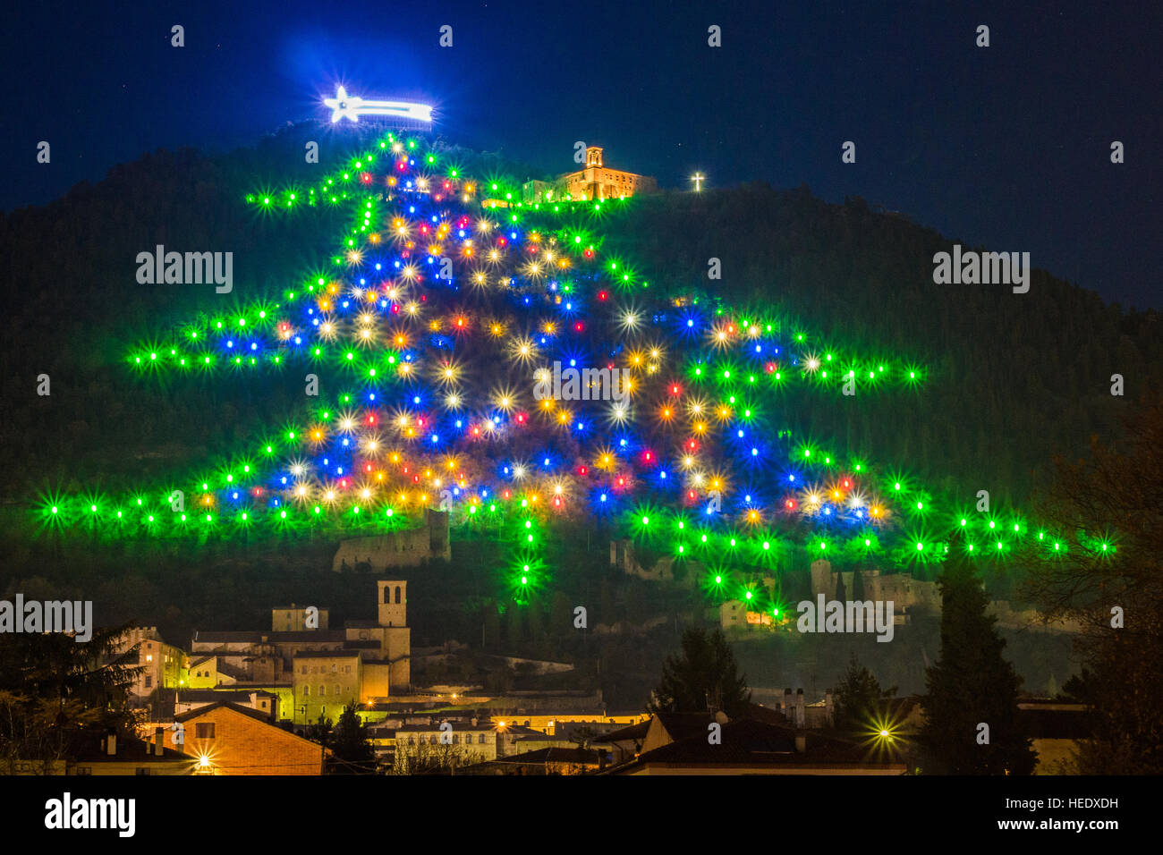 "Albero di Natale' illuminazione sul Monte Ingino sopra la città di Gubbio, Perugia provincia, regione Umbria, Italia. Foto Stock