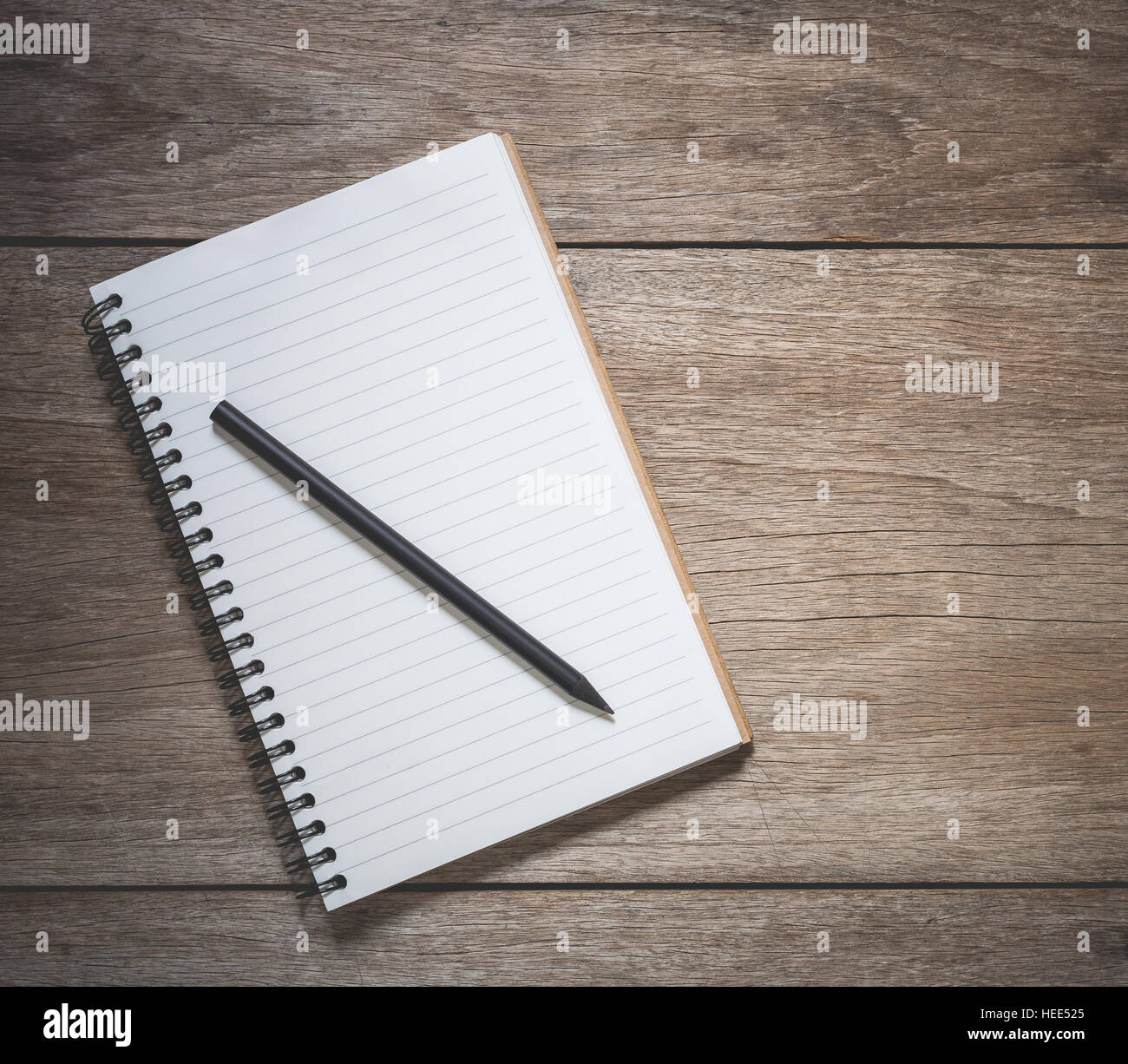Vista superiore del libro bianco e nero a matita sul vecchio asse di legno sfondo Foto Stock