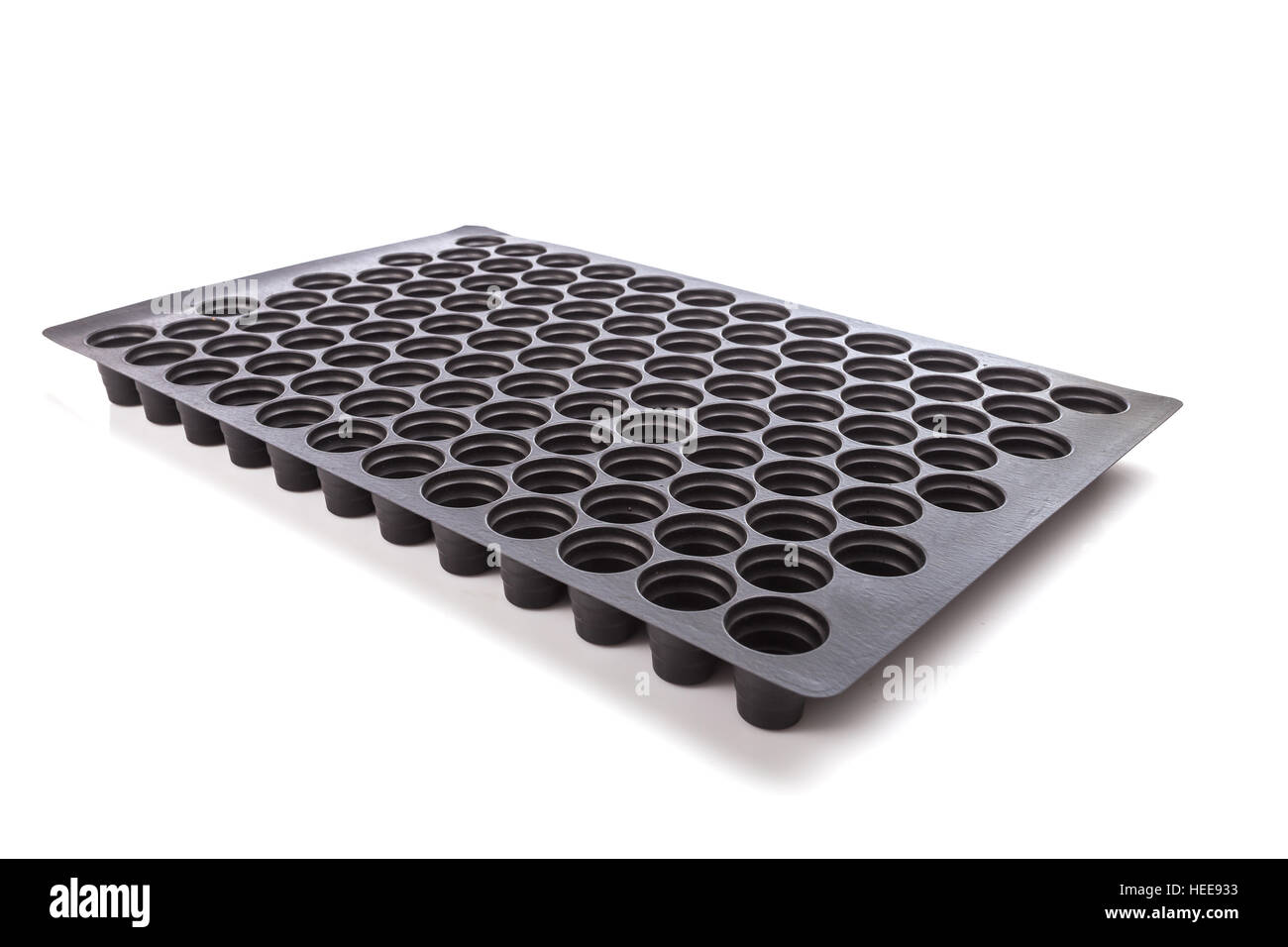 Vuoto nero vassoio di plastica con foro per i semenzali isolati su sfondo bianco Foto Stock
