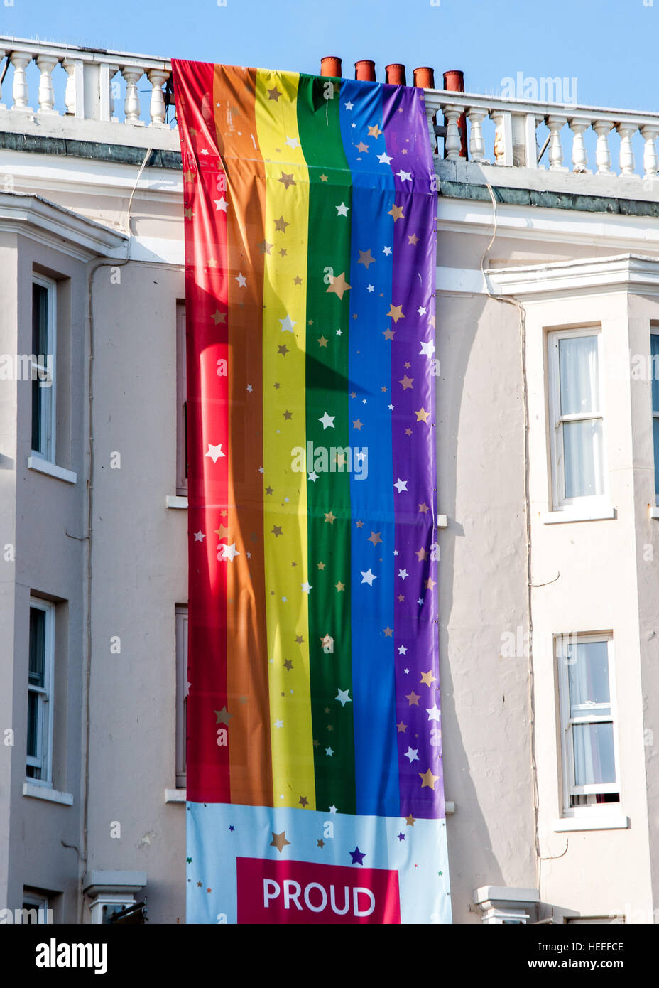 Una bandiera arcobaleno appeso sulla costruzione in Brighton, East Sussex, England, Regno Unito Foto Stock