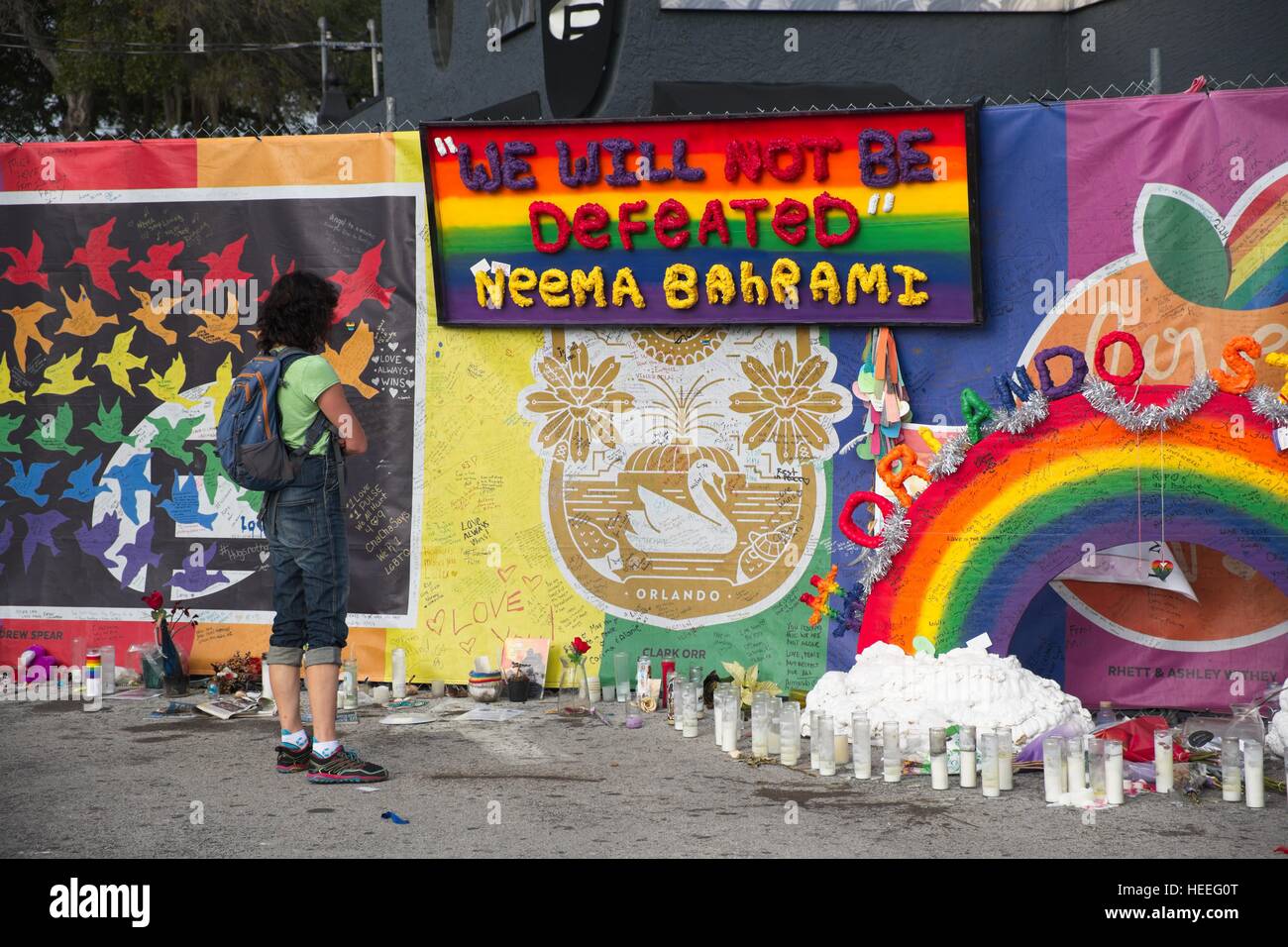 Un passerby smette di leggere omaggi a sinistra un memoriale di fortuna intorno al nightclub di impulsi 18 Dicembre 2016 a Orlando, Florida. Il 12 Giugno 2016 49 persone sono state uccise e 53 ferite in più letali riprese di massa mediante un unico pistolero nella storia degli Stati Uniti e più letali attacchi terroristici sul suolo americano dopo gli eventi dell'11 settembre 2001. Foto Stock