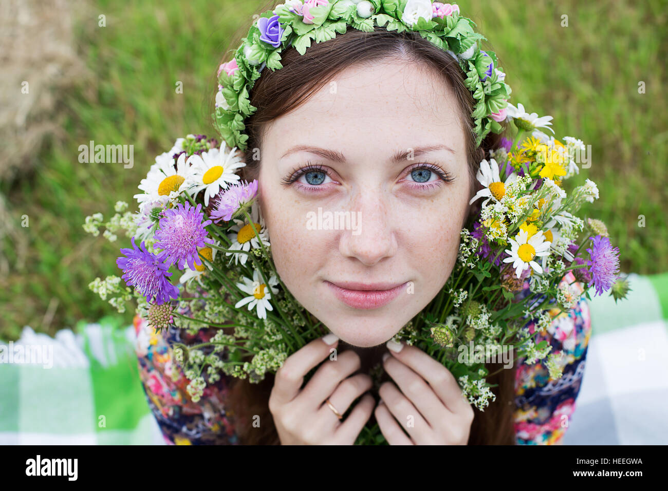 Freckled ragazza seduta con separazione wild bouquet di fiori Foto Stock