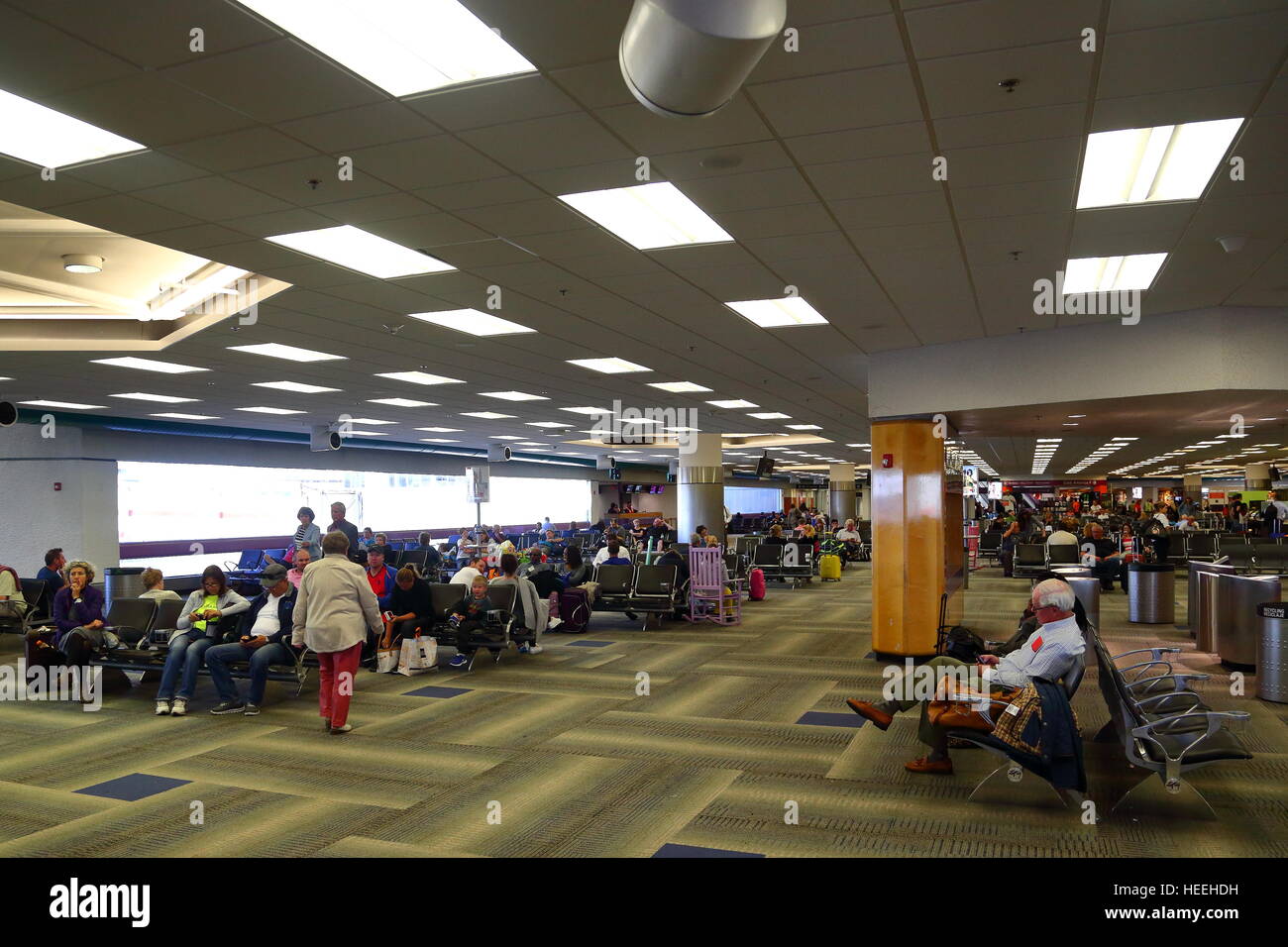 I passeggeri in attesa per i loro voli all'interno del terminal all'Aeroporto di Miami, Florida, Stati Uniti d'America Foto Stock