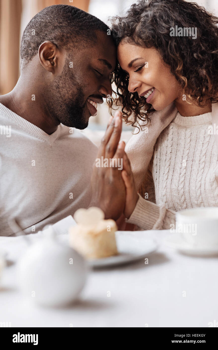 Soulful sorridente americano africano giovane toccando le mani nel cafe Foto Stock