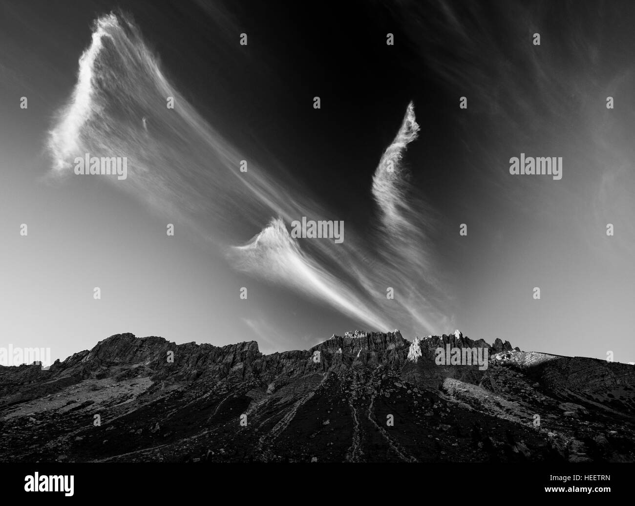 Cirrus nuvole sopra le Odle gruppo montuoso. Le Dolomiti della Val di Funes. Bianco nero paesaggio di montagna delle Alpi italiane. L'Europa. Foto Stock