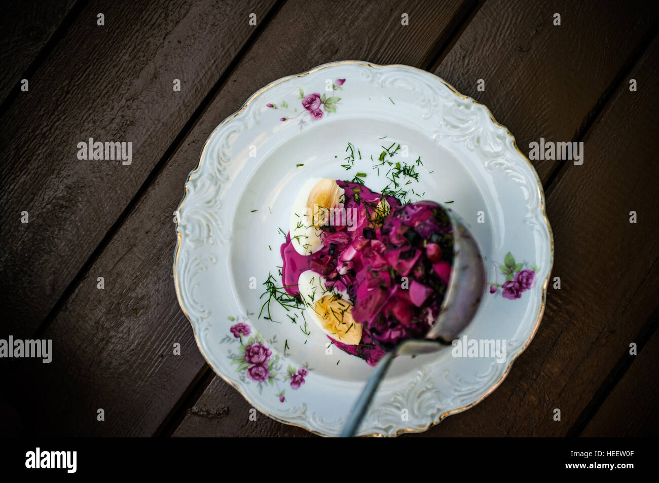 Versando freddo zuppa di barbabietole con aneto e delle uova sul tavolo Foto Stock