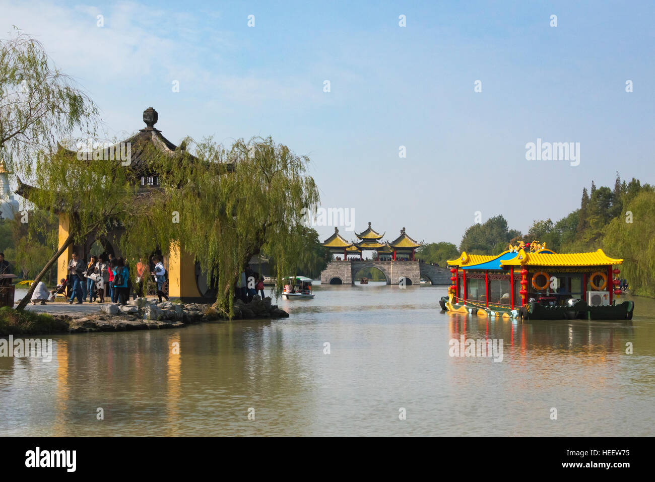 Il padiglione e la barca turistica su Slim West Lake, Lotus Bridge (chiamato anche Cinque Pagoda) ponte in distanza, Yangzhou Jiangsu, Cina Foto Stock