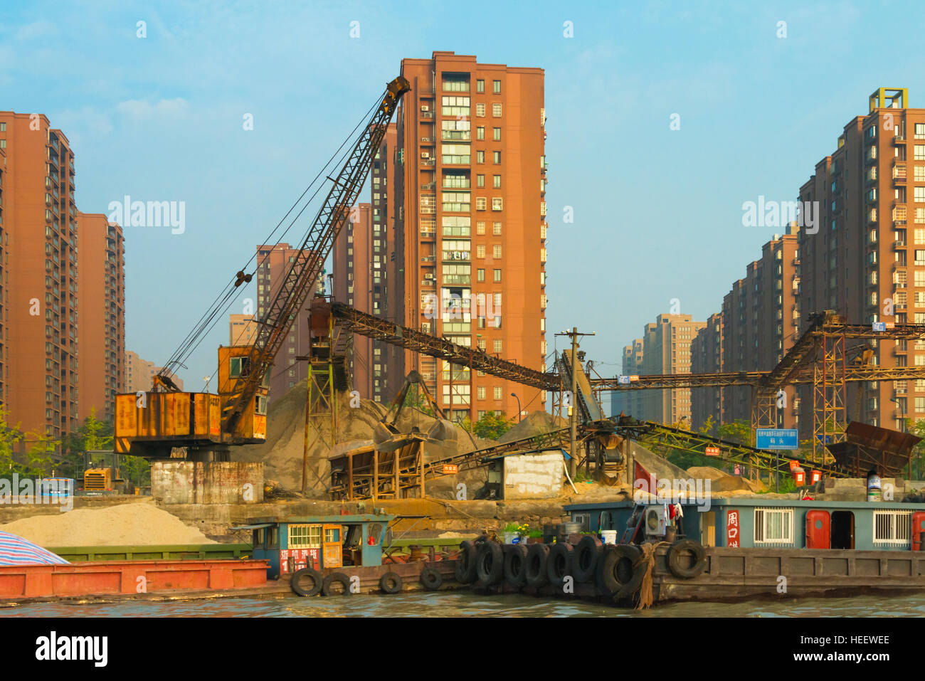 Chiatte a banchina di carico sul Canal Grande, moderna città lungo la riva del fiume, Hangzhou, nella provincia di Zhejiang, Cina Foto Stock
