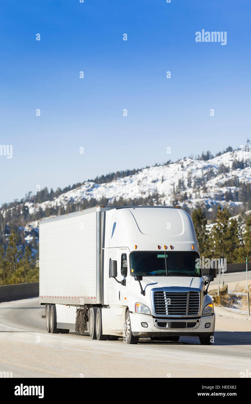 White Semi carrello 18-Wheeler sulla montagna innevata pass. Foto Stock