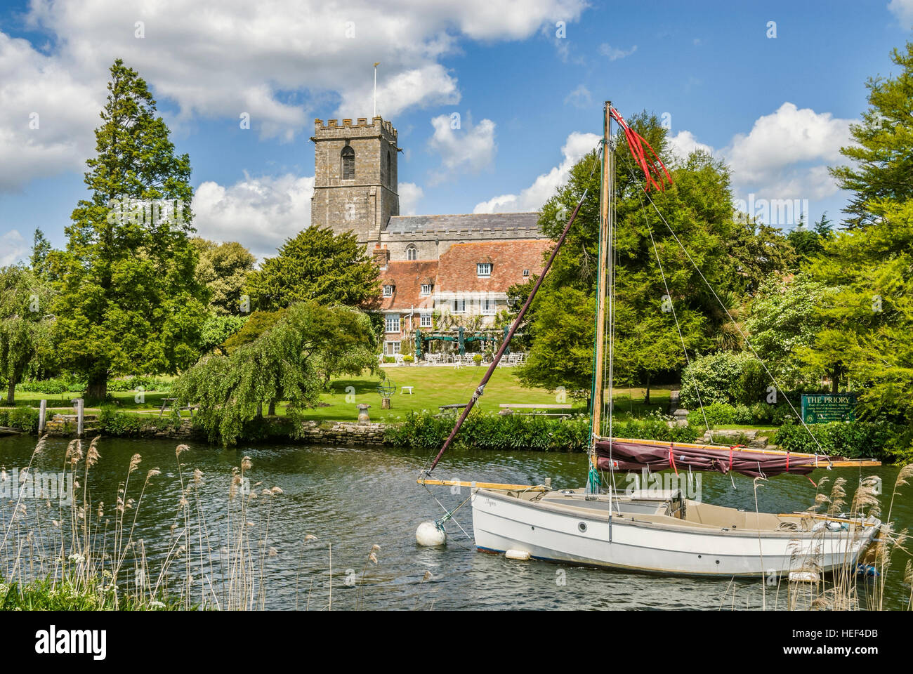 Nave a vela sul fiume Frome vicino a Wareham con la Signora Santa Maria la Chiesa in background, Dorset, sud-est dell' Inghilterra. Foto Stock