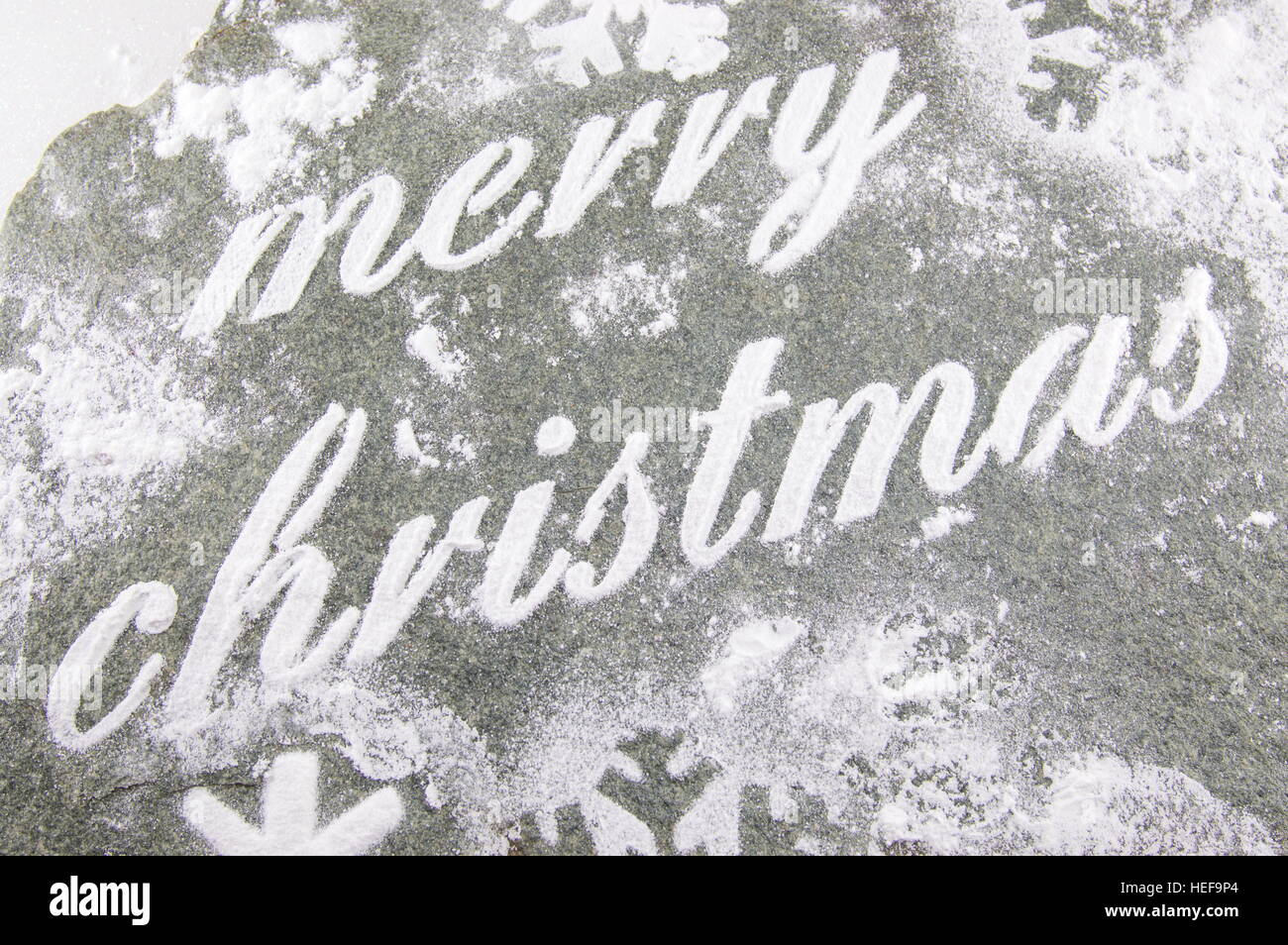 Buon Natale nota scritta con lo zucchero in polvere e i cookie di vacanza Foto Stock