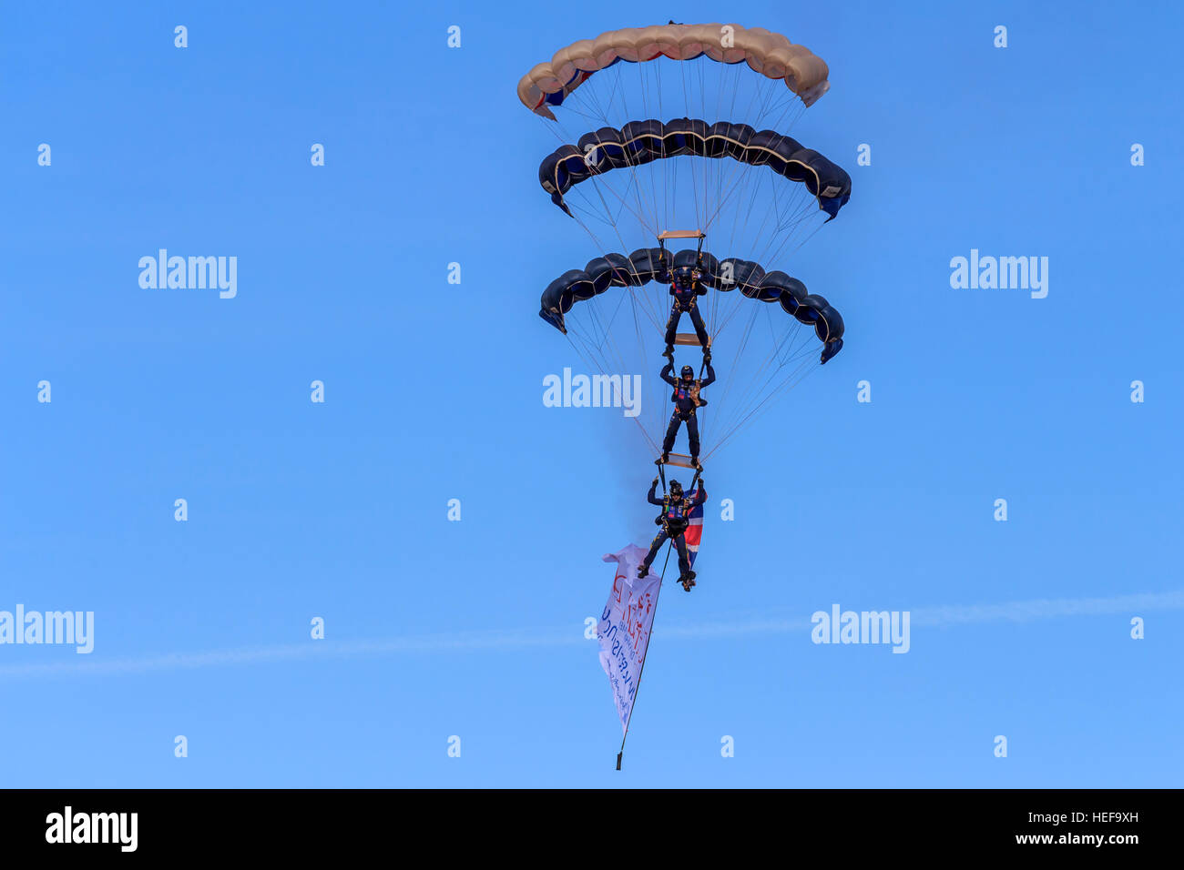 Tre delle Tigri Freefall ParachuteTeam membri impilati come il loro approccio alla terra di fronte alla folla in airshow di Southport Foto Stock