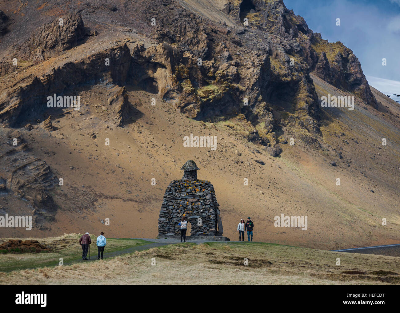 I turisti alla statua di nome Bardur Snaefellsass, Arnarstapi, Snaefellsnes Peninsula, Islanda. Foto Stock