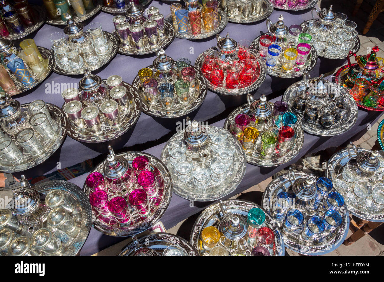 Teiere tradizionale tè con gli occhiali su un vassoio venduti nel souk di Marrakech, Marocco Foto Stock