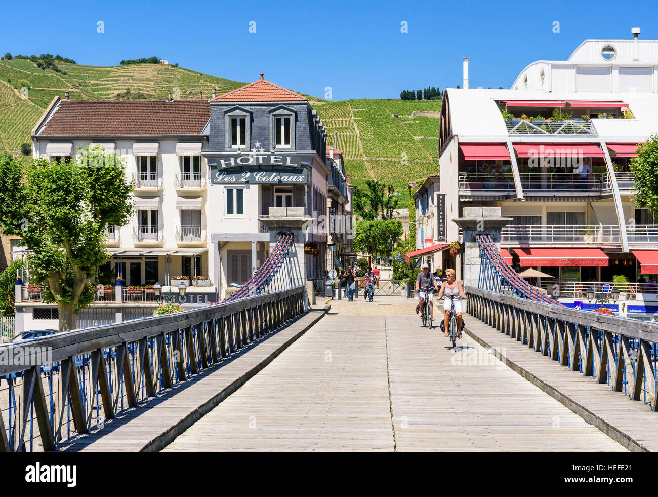 Il Marc Seguin Bridge guardando verso la città e vigneti di Tain-l'Hermitage, Drôme, Auvergne-Rhône-Alpes, Francia Foto Stock
