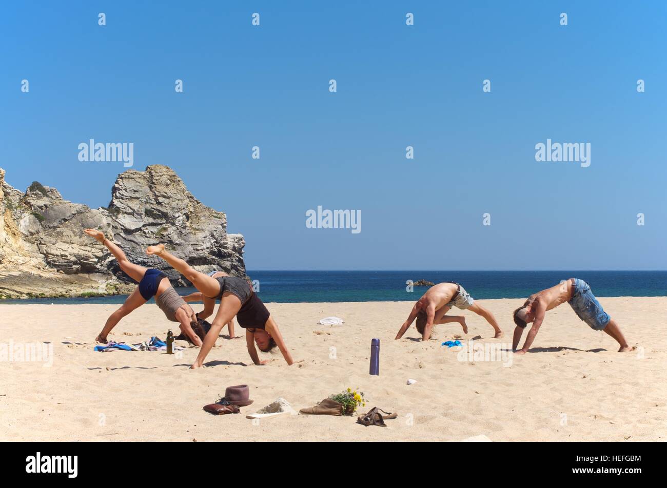 Gruppo di persone facendo yoga a Praia do Barranco, Portogallo Foto Stock