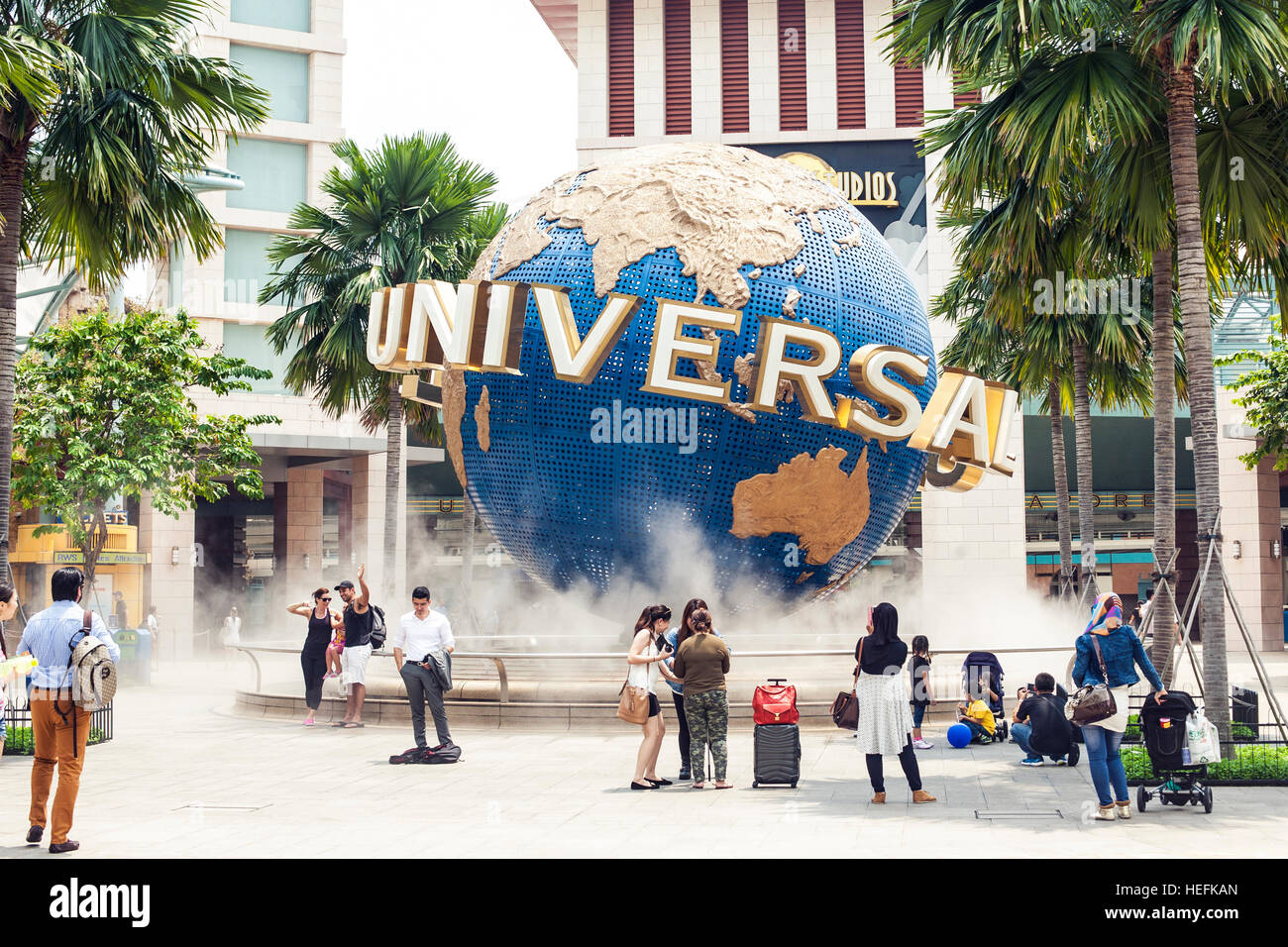 Turisti e il parco a tema di visitatori di fotografare il grande globo rotante fontana davanti agli Universal Studios Foto Stock