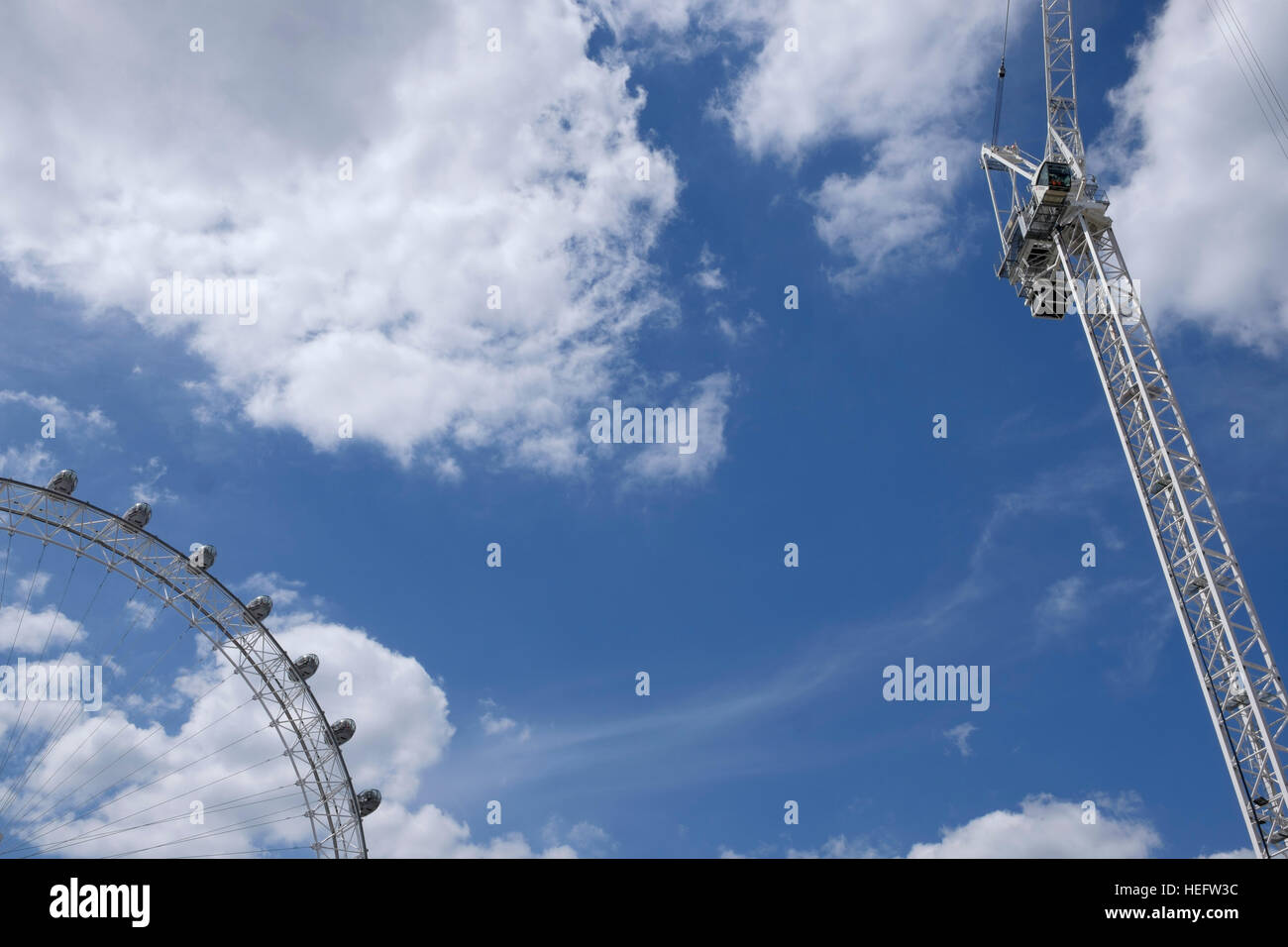 Gru preso contro una torbida e cielo blu accanto al London Eye a Londra Foto Stock
