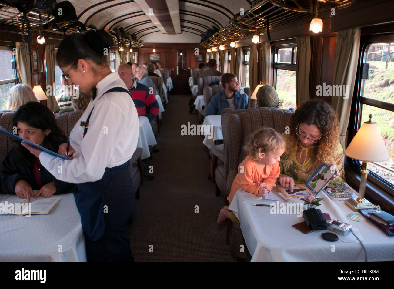 Andean Explorer, lusso in treno da Cusco a Puno. Il treno all'interno. I camerieri servono delizie in Esplora andina treno Orient Express che passa da Foto Stock