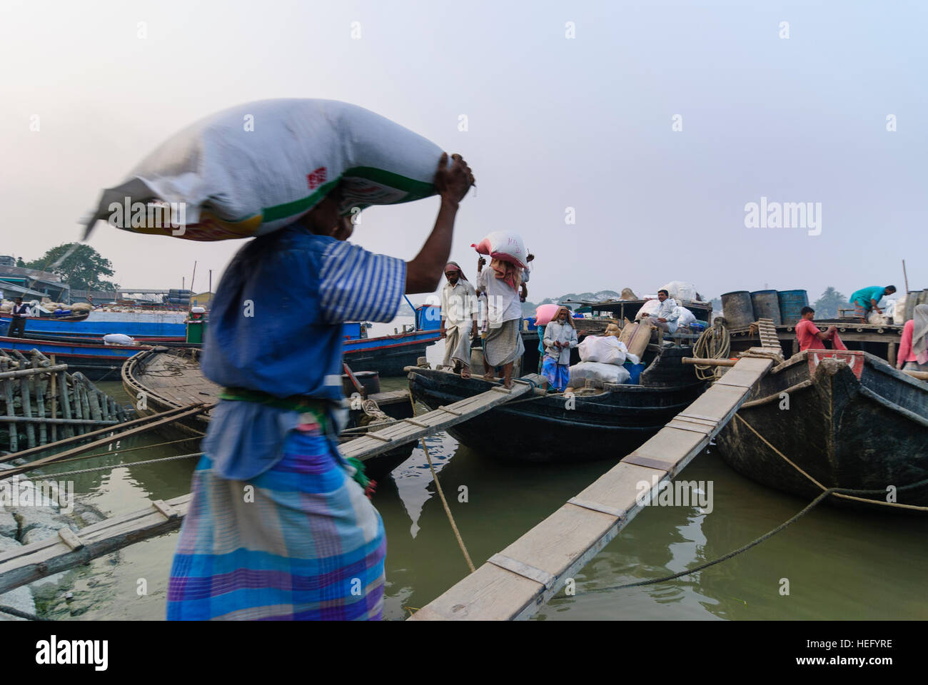Khulna: porto sul fiume Bhairab, portapacchi con sacchi, Khulna Division, Bangladesh Foto Stock