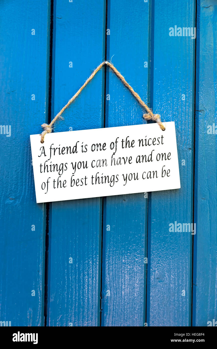 Firmare con l'inglese si dice "Un amico è una delle più belle cose che si possono avere e una delle cose migliori che si può essere' su blu porta in legno Foto Stock