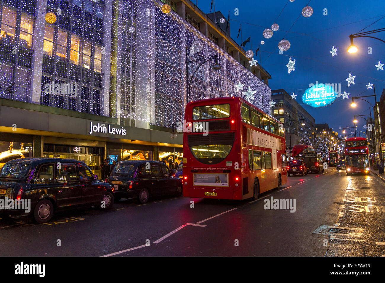 Un autobus e taxi fuori dal grande magazzino John Lewis a Natale su Oxford St Londra, Londra UK Foto Stock