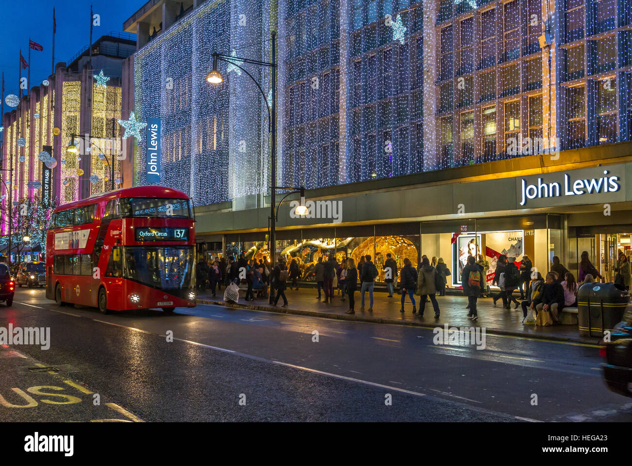 Folle di acquirenti di Natale fuori dal grande magazzino John Lewis su Oxford Street di Londra al tempo di Natale, Londra, Regno Unito Foto Stock