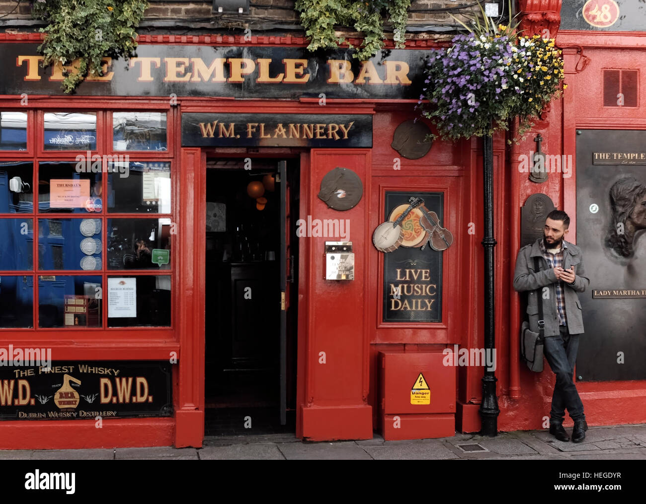 Solo maschio appoggiato sulla facciata anteriore di un pub nella zona Temple Bar di Dublino il 21 maggio 2015. Foto Stock