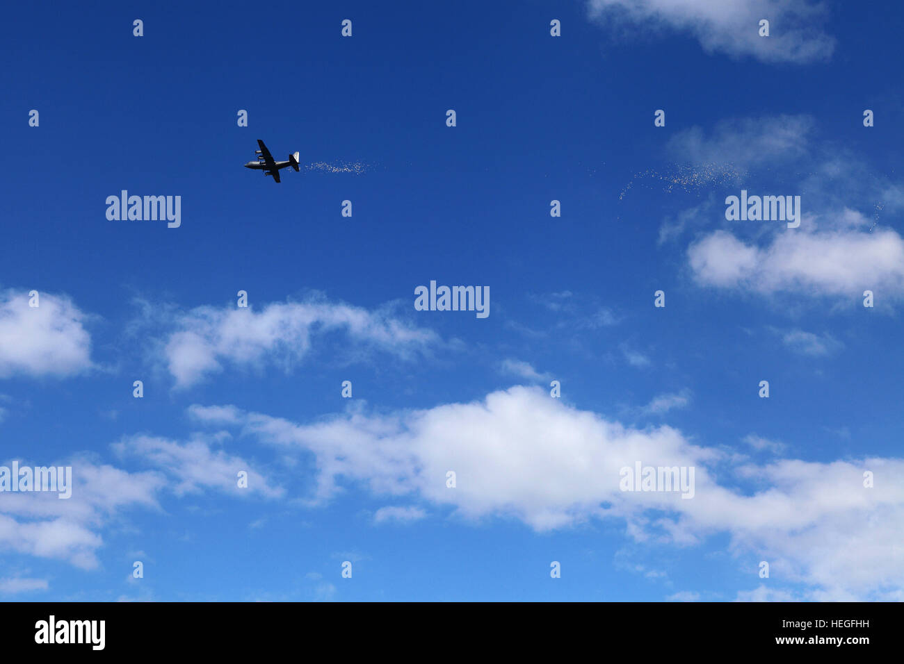Il piano di trasporto diffusione di opuscoli contro blu cielo molto nuvoloso Foto Stock