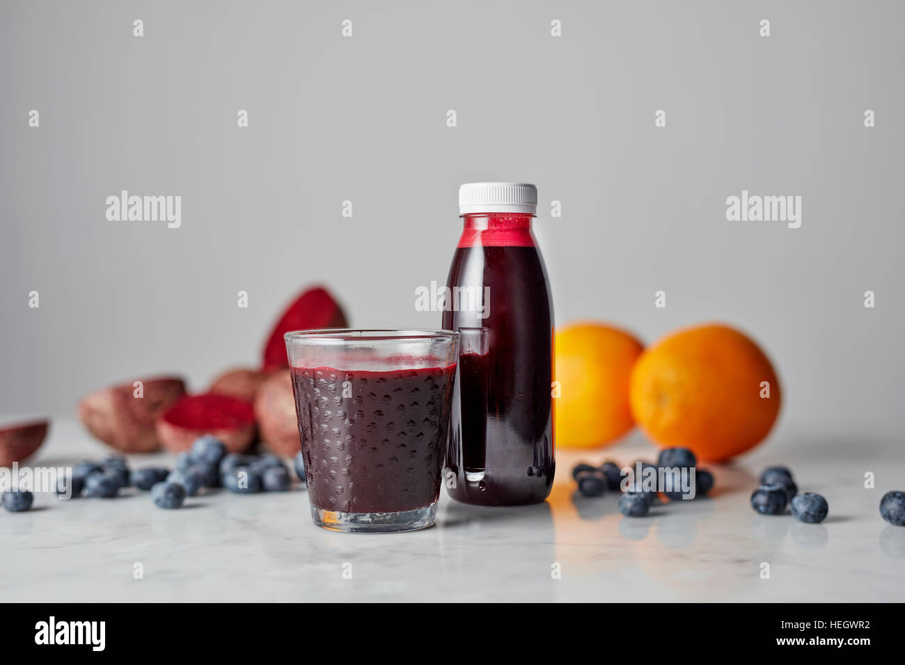 Beetroot e succo d'arancia fresco sano bicchiere di vetro plastica bottiglia di vitamina liquido vetro che serve estratto estrazione polpa Foto Stock