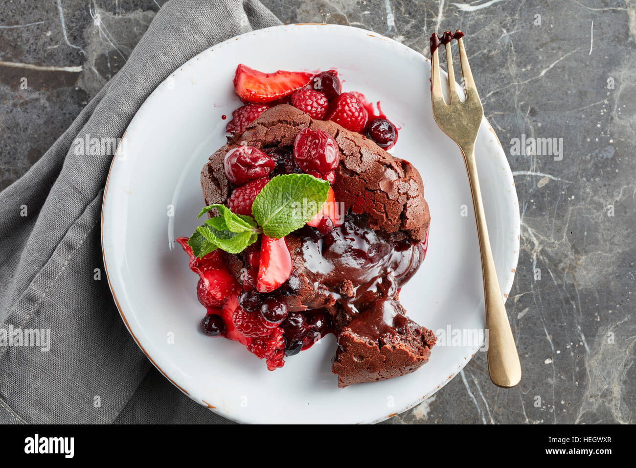frutta fondente al cioccolato che trasuda dessert caldo appena sfornato budino dolce alla fragola alla frutta allettante, gustoso, ricco e appetitoso Foto Stock