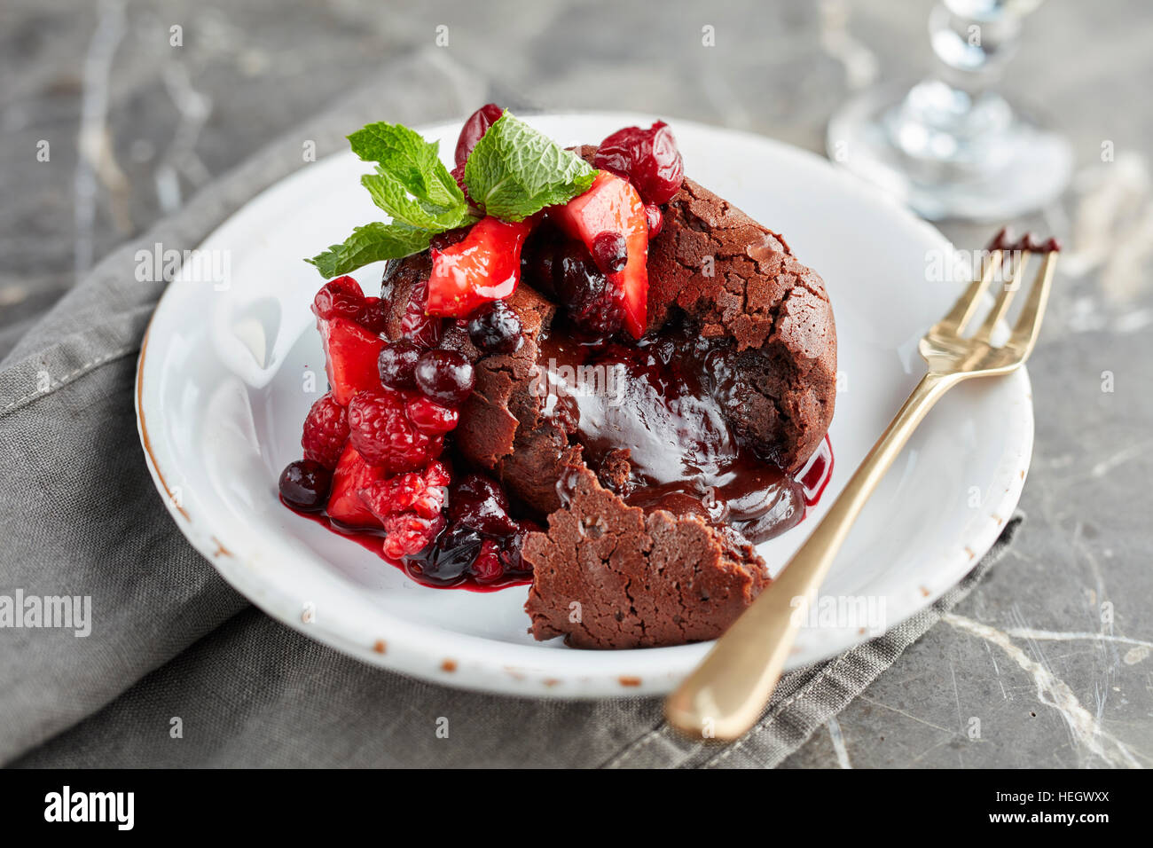 frutta fondente al cioccolato che trasuda dessert caldo appena sfornato budino dolce alla fragola alla frutta allettante, gustoso, ricco e appetitoso Foto Stock