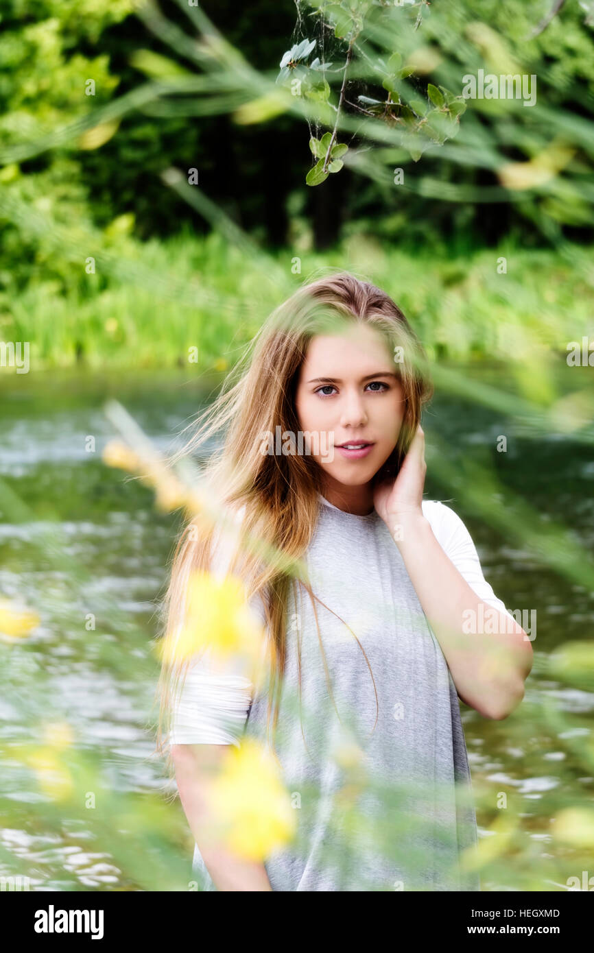Attraente Caucasica Girl Teen in piedi dal fiume grigio Top Foto Stock