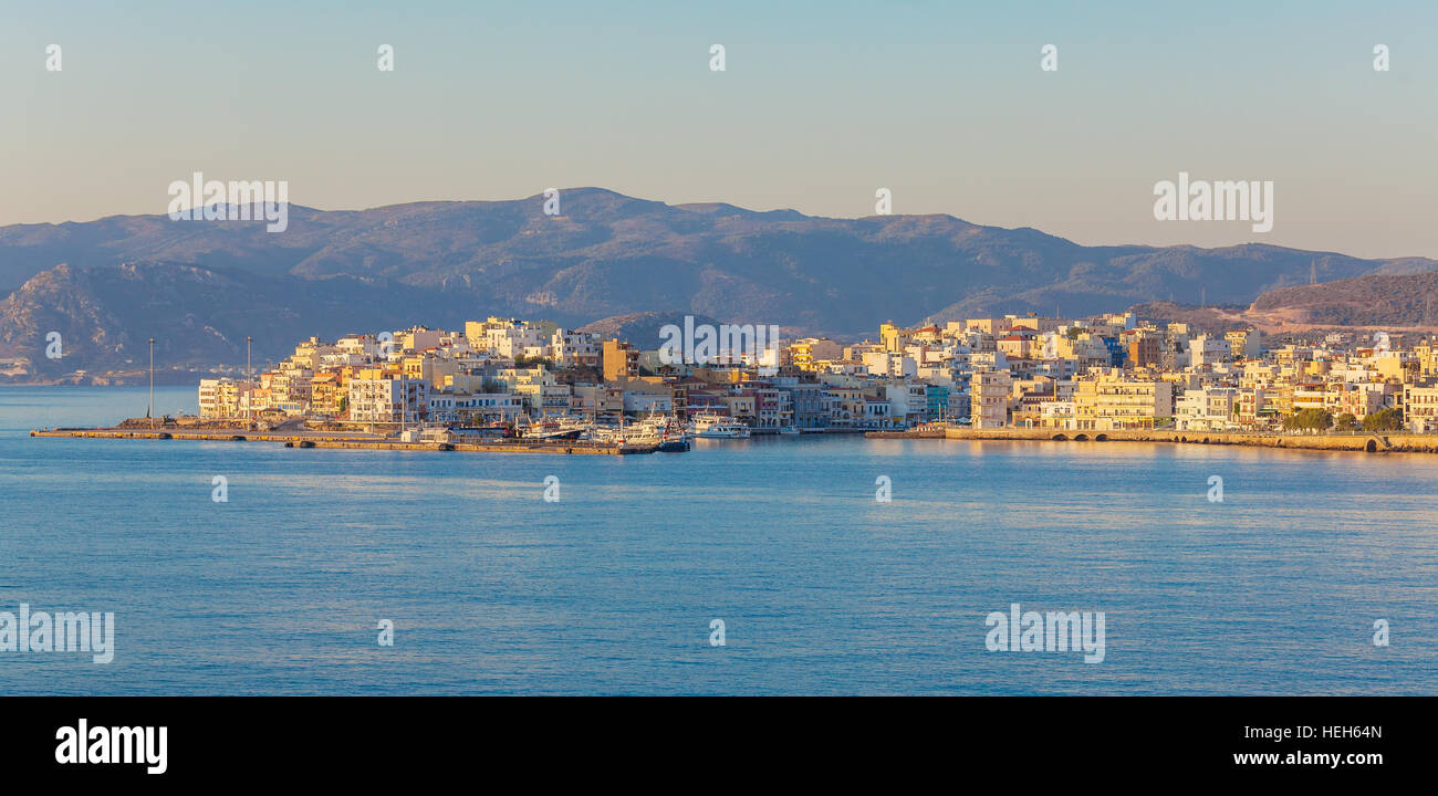 Panorama della città, illuminato dalla luce gialla del sole nascente, Agios Nikolaos, Creta Foto Stock
