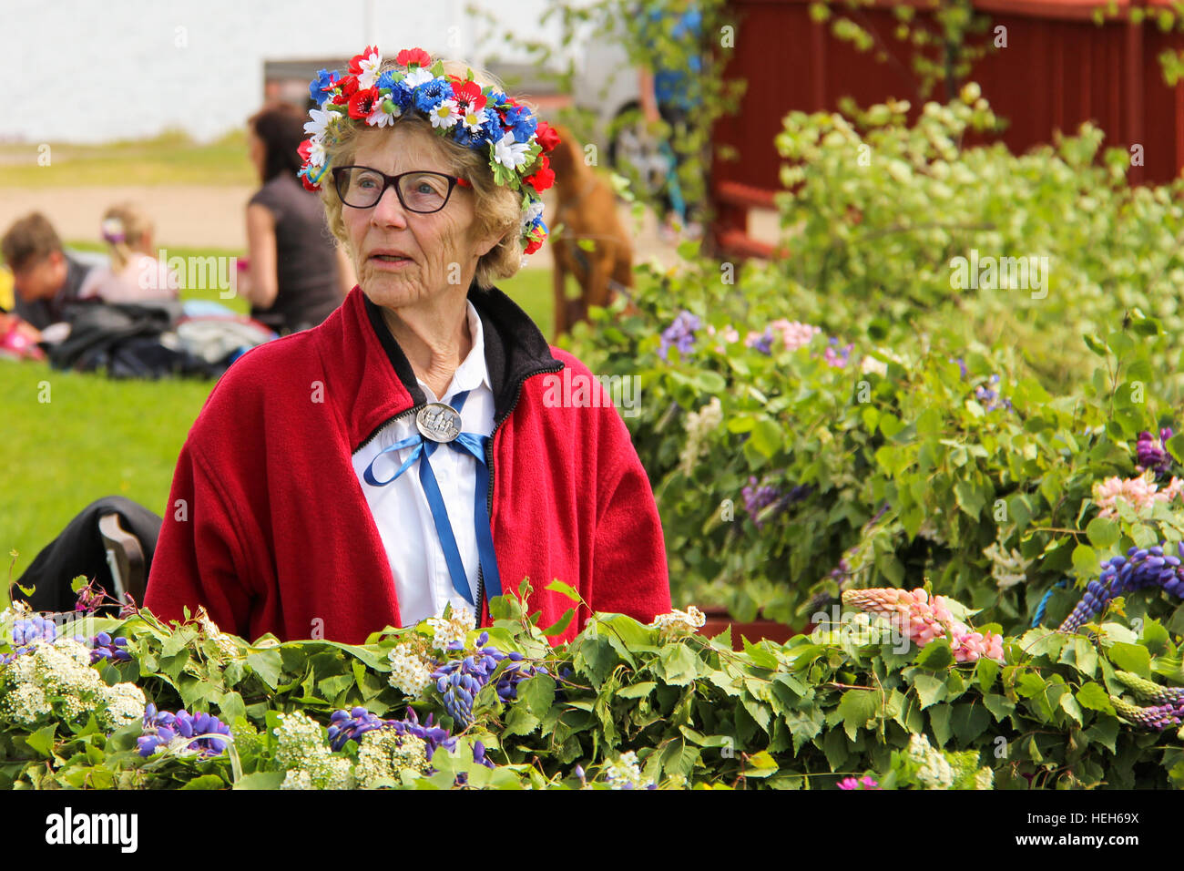 Un'anziana donna svedese con una corona di fiori preparare per la festa di mezza estate a Läcko Slott in Svezia Foto Stock