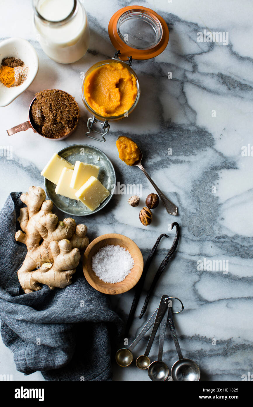 Gli ingredienti di cucina in marmo sulla superficie di lavoro. Il burro, lo zenzero, latte, spezie. Foto Stock