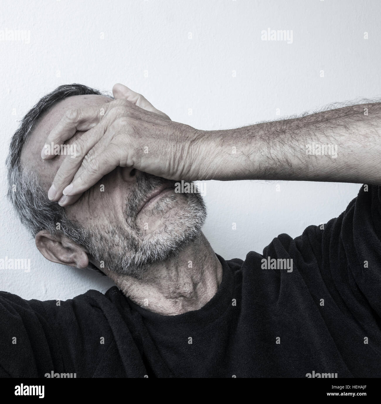 Uomo maturo negli anni cinquanta con la mano sulla faccia. La salute mentale, depressione...concept Foto Stock