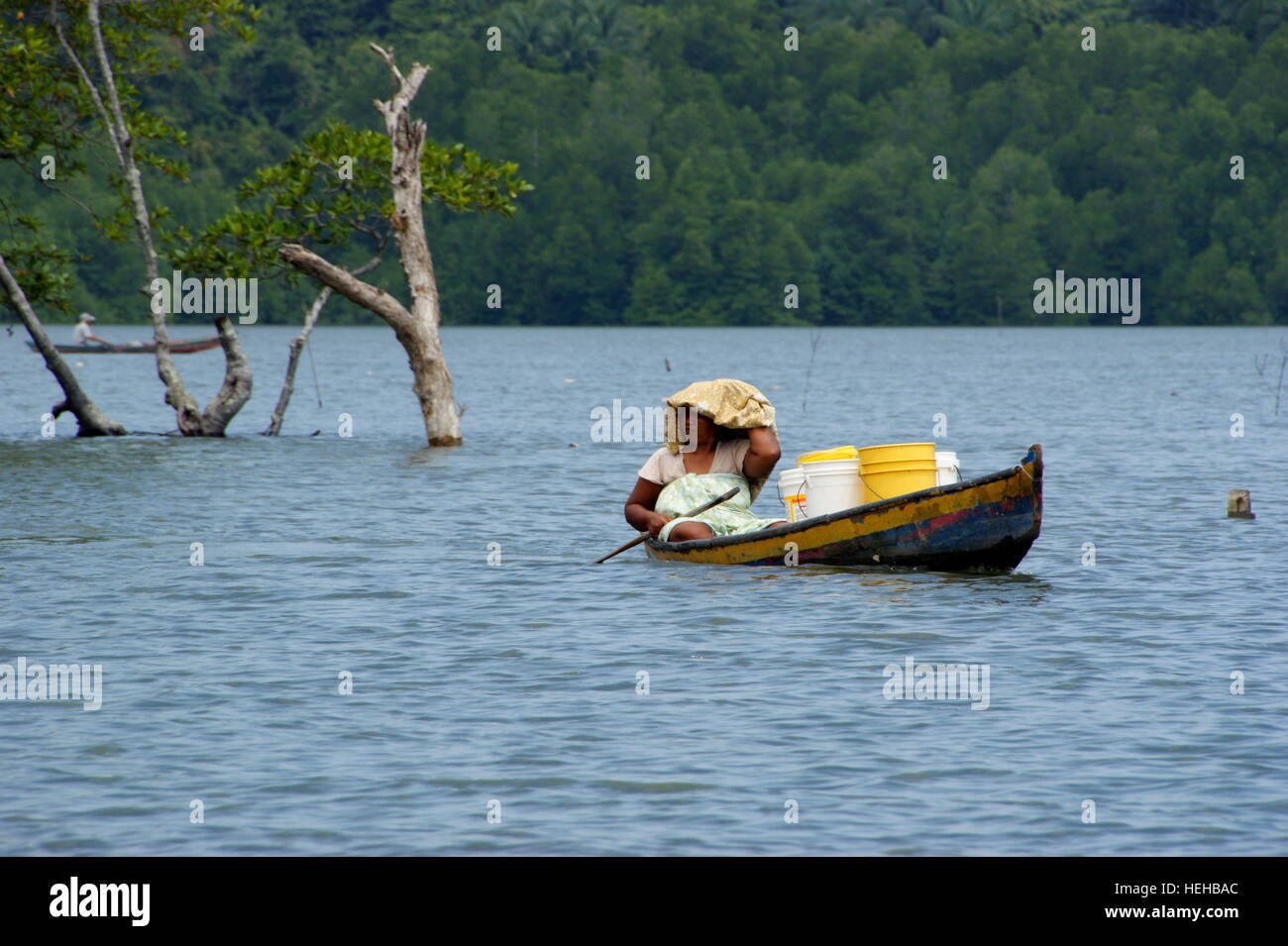 La donna porta una barca da carico. Villaggio di Pescatori sull'acqua. Fiume Mengkabong, Kota Kinabalu, Sabah Borneo Malese. 22 Giu 2012 Foto Stock