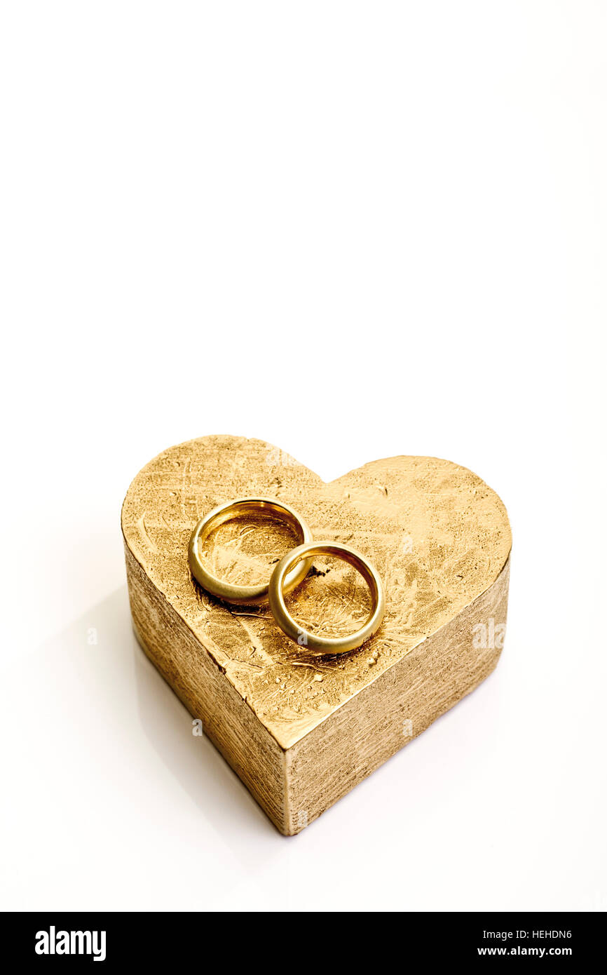 Gli anelli di nozze, bande su un cuore a forma di cartone dorato confezione regalo Foto Stock