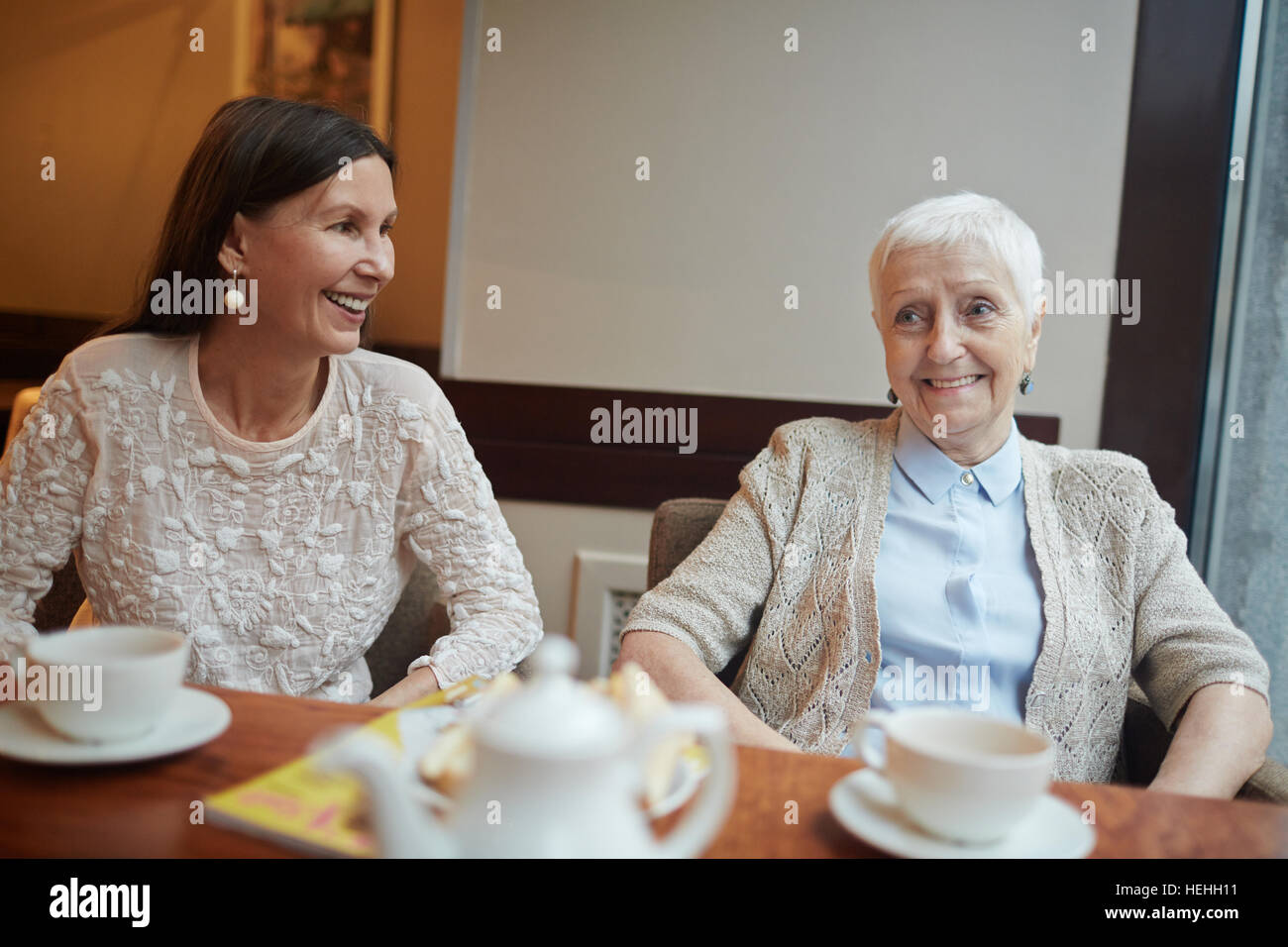 Due femmine senior trascorrere serate in cafe Foto Stock