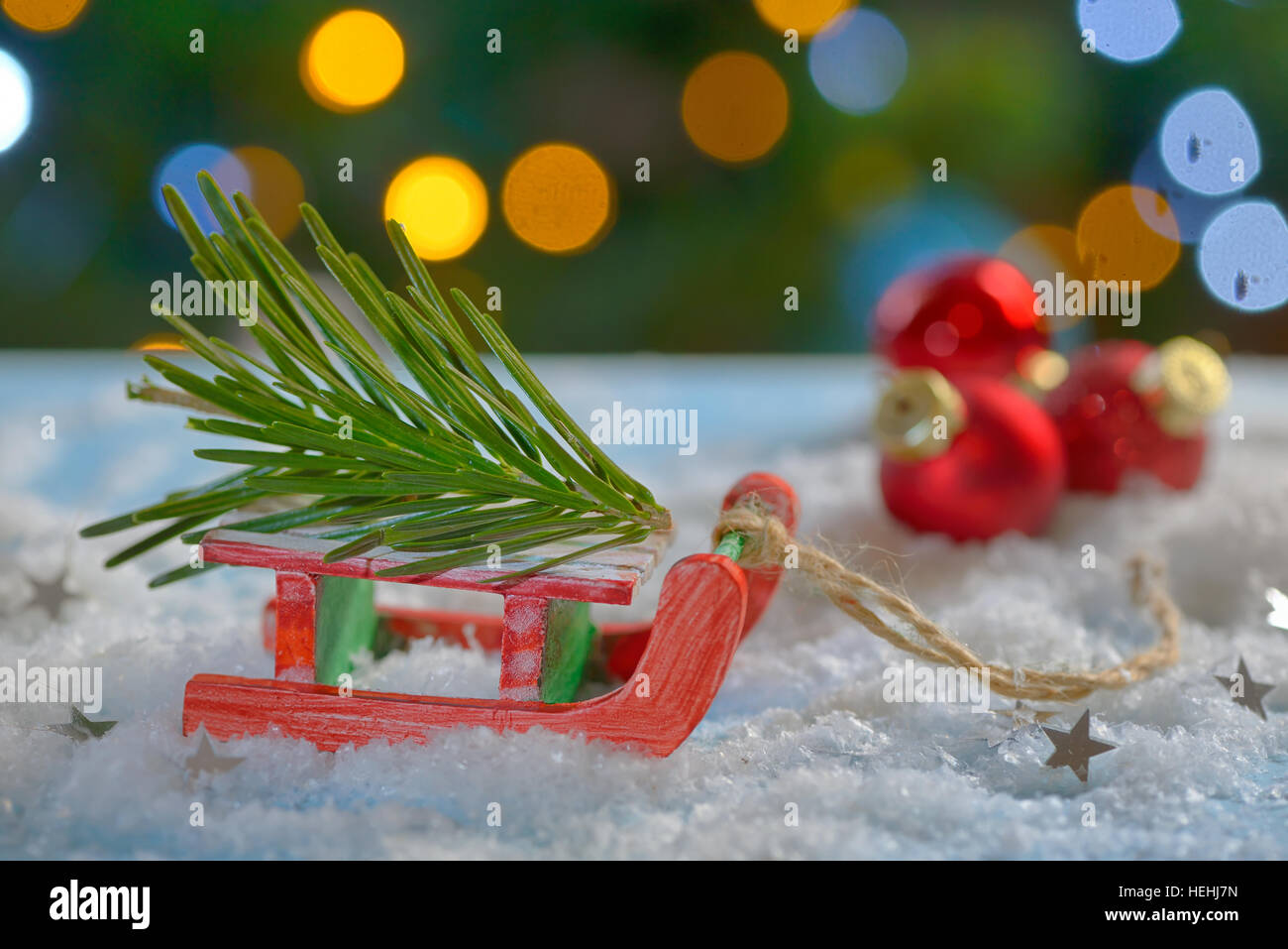 Red sleigh giocattolo e albero di Natale sulla neve falsa Foto Stock