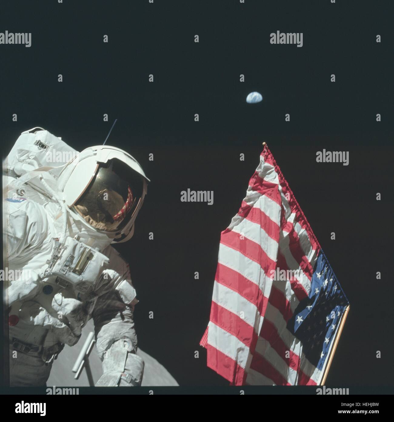 La NASA Apollo 17 atterraggio lunare missione astronauta Harrison Schmitt sorge accanto a una bandiera americana durante la prima attività extravehicular sulla superficie lunare Dicembre 11, 1972 sulla luna. Astronauta Cernan gene può essere visto nelle visiere di riflessione. Foto Stock