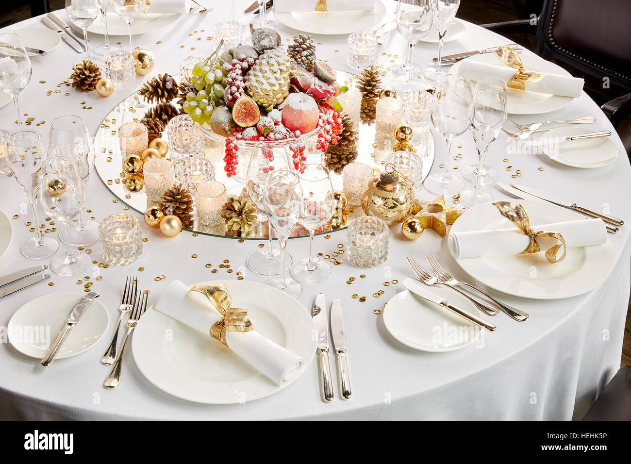 Tavolo bianco Natale dessert dolce budino tavola rotonda speciale giorno di Natale ristorante presentazione piatti posate impostazioni specchio pezzo centrale Foto Stock