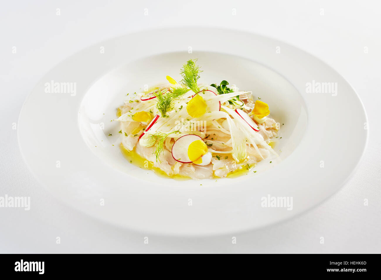 Ceviche pesce crudo Perù Tom Aiken rafano agrumi limone lime frutti di mare bianco piatto bianco panno da tavolo tagliato fuori fresco zesty Michelin star chef Foto Stock